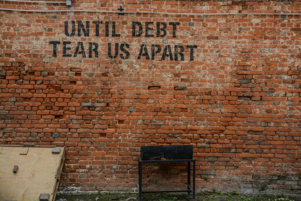 Schulden Spruch an Wand geschrieben